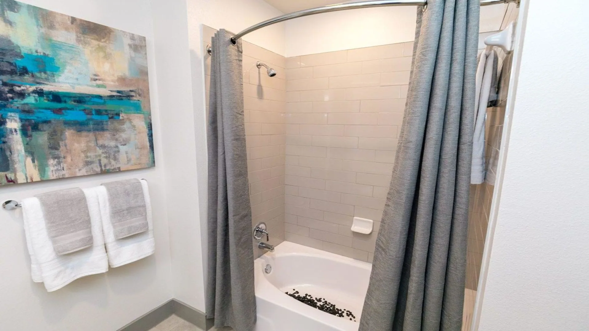 a bathroom with a shower curtain, tub and toilet at The Argon