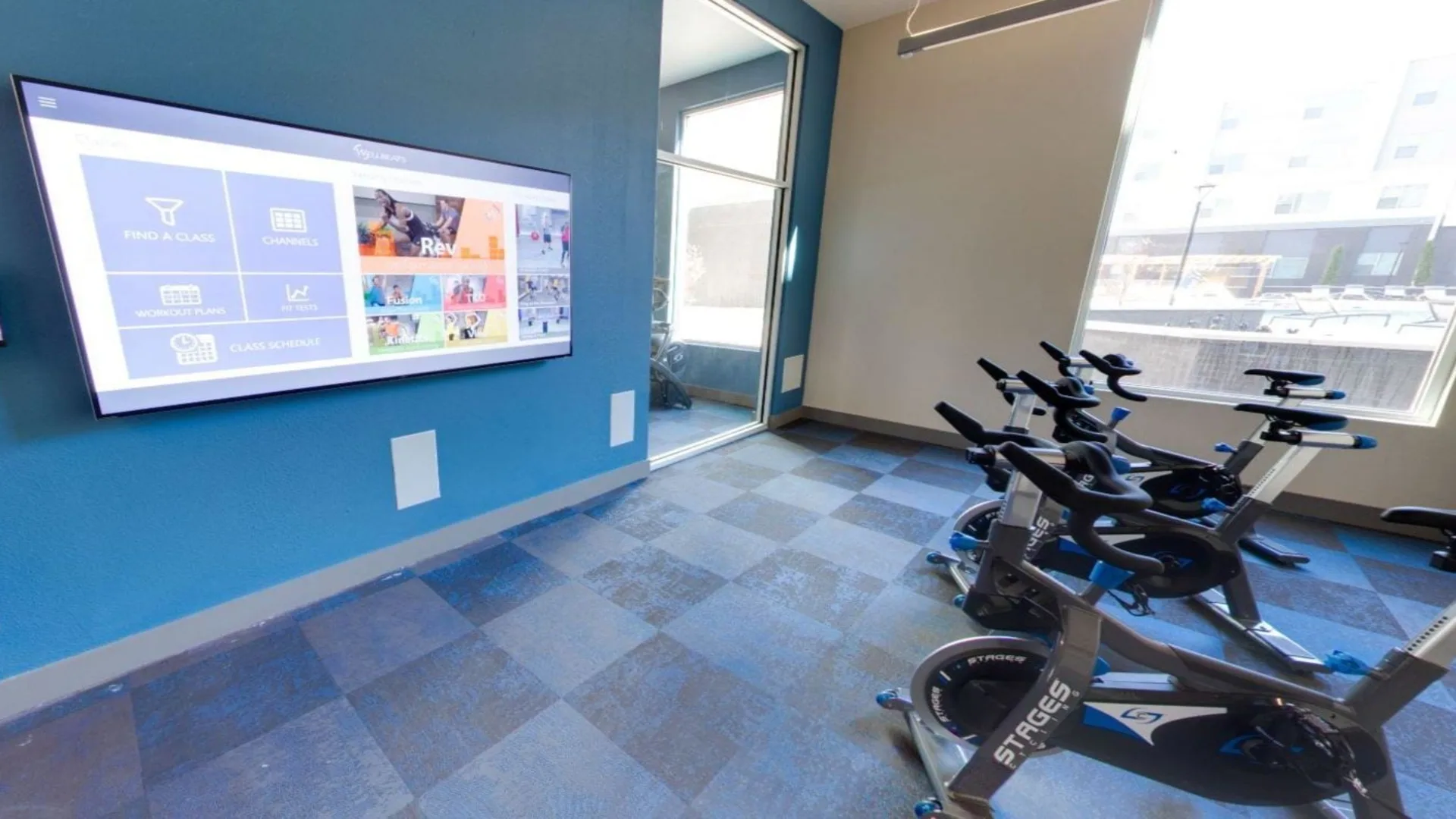 a room with exercise bikes and a television at The Argon