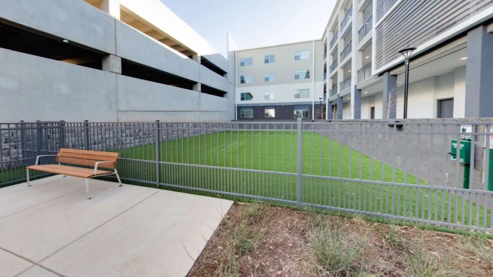 a bench in front of a fence with grass at The Argon